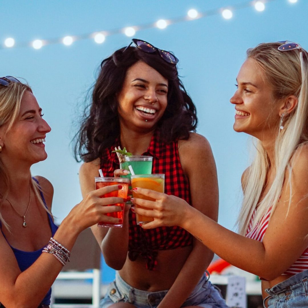 Young girls having a party in a beach - Teenagers drinking cocktails - Friends having fun in bar